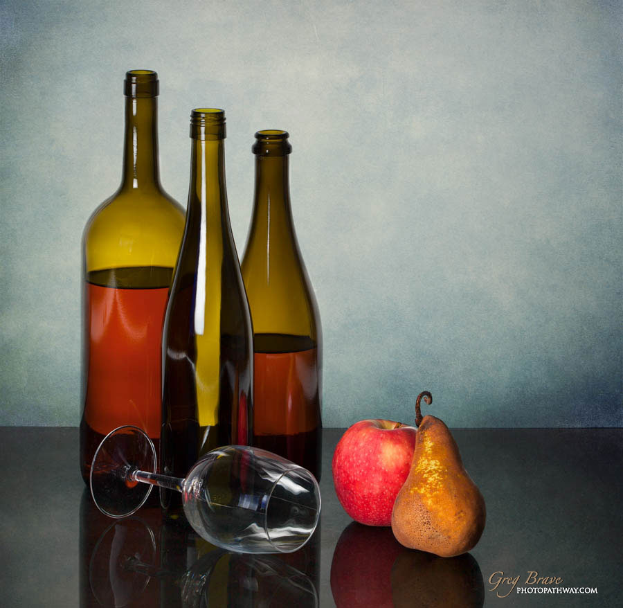 Still life with bottles glass and fruits in color by greg brave