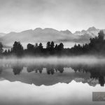 Beautiful reflections of Southern Alps at Lake Matheson, New Zealand, in the early morning mist, in black and white