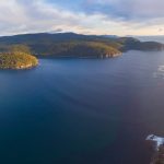 Aerial panorama of Fortescue Bay at sunset. Tasman National Park, Victoria, Australia