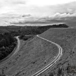 Winding road along Cardinia Reservoir dam wall in black and white. Melbourne, Australia.