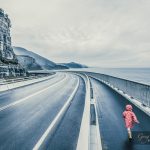 Child running on Sea Cliff Bridge, Grand Pacific Drive, Sydney, Australia. Image has vintage filter applied.