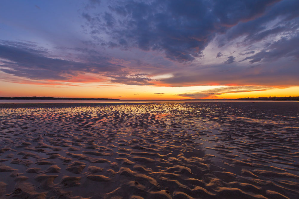 Beautiful glowing sunset reflections in sand ripples, at Inverloch Foreshore Beach, Gippsland, Victoria, Australia